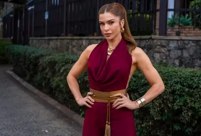 Personagem Arminda com look sofisticado em tom vinho e acessórios dourados na novela Três Graças.