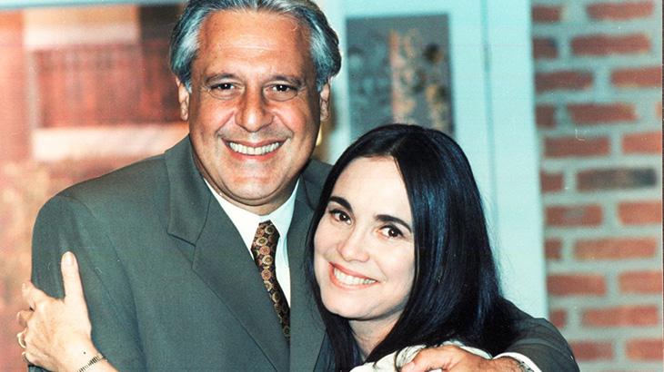 Os personagens Helena (Regina Duarte) e Atílio (Antonio Fagundes) sorrindo e posando juntas em cena da novela Por Amor.